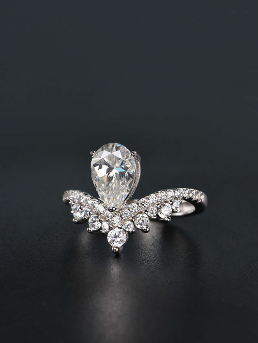 Alternative pear shaped moissanite engagement ring with a chevron tiara crown worn on a finger