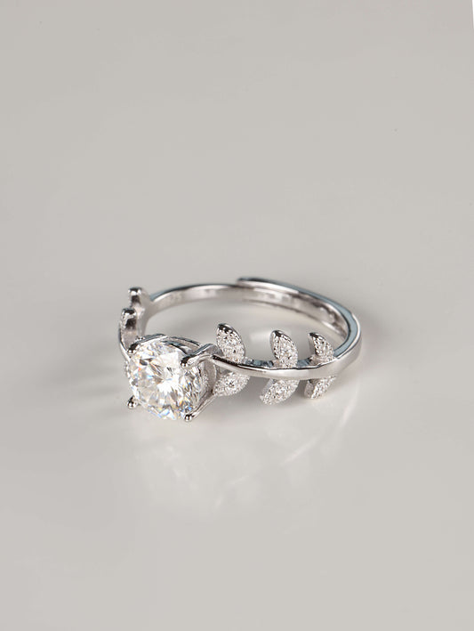 Close up of a woman wearing a 1 carat botanical moissanite engagement ring on her index finger