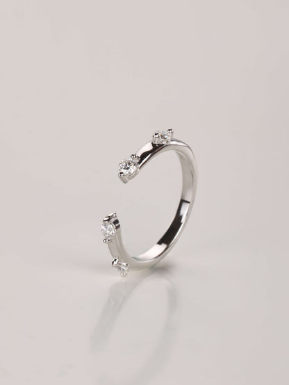 A modern 925 sterling silver stacking ring with a front gap design and delicate spaced stone accents.