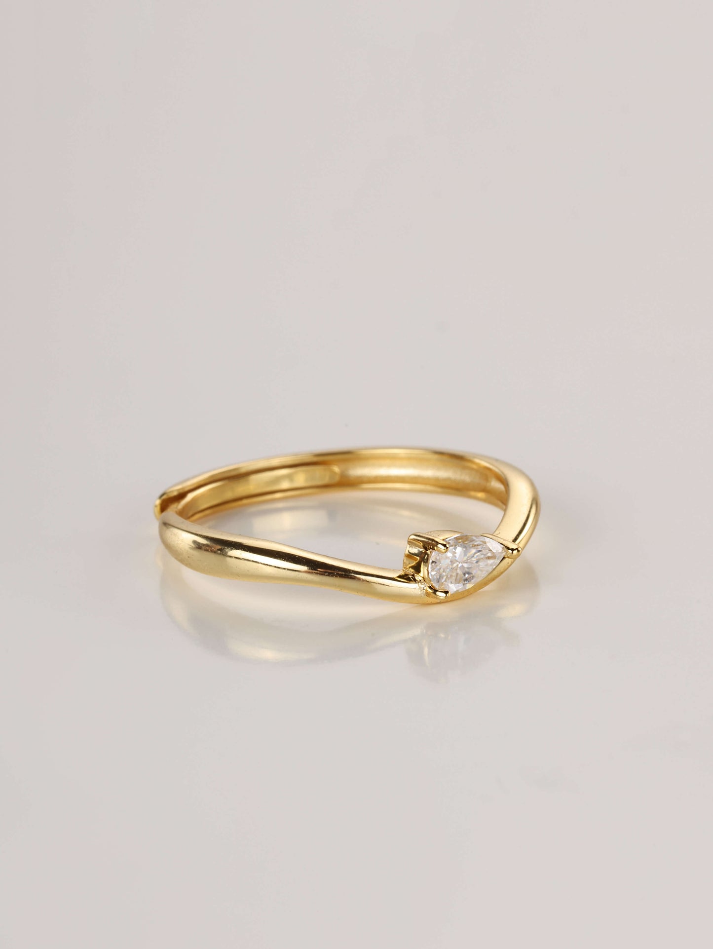 A modern 925 sterling silver wavy stacking ring featuring a 0.5ct pear-cut moissanite centre stone.