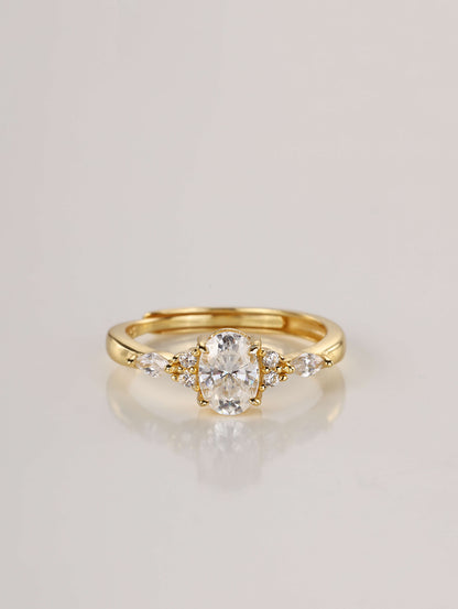 A gold adjustable ring featuring a 1-carat oval moissanite centre stone flanked by marquise and round side stones, set against a clean white background.