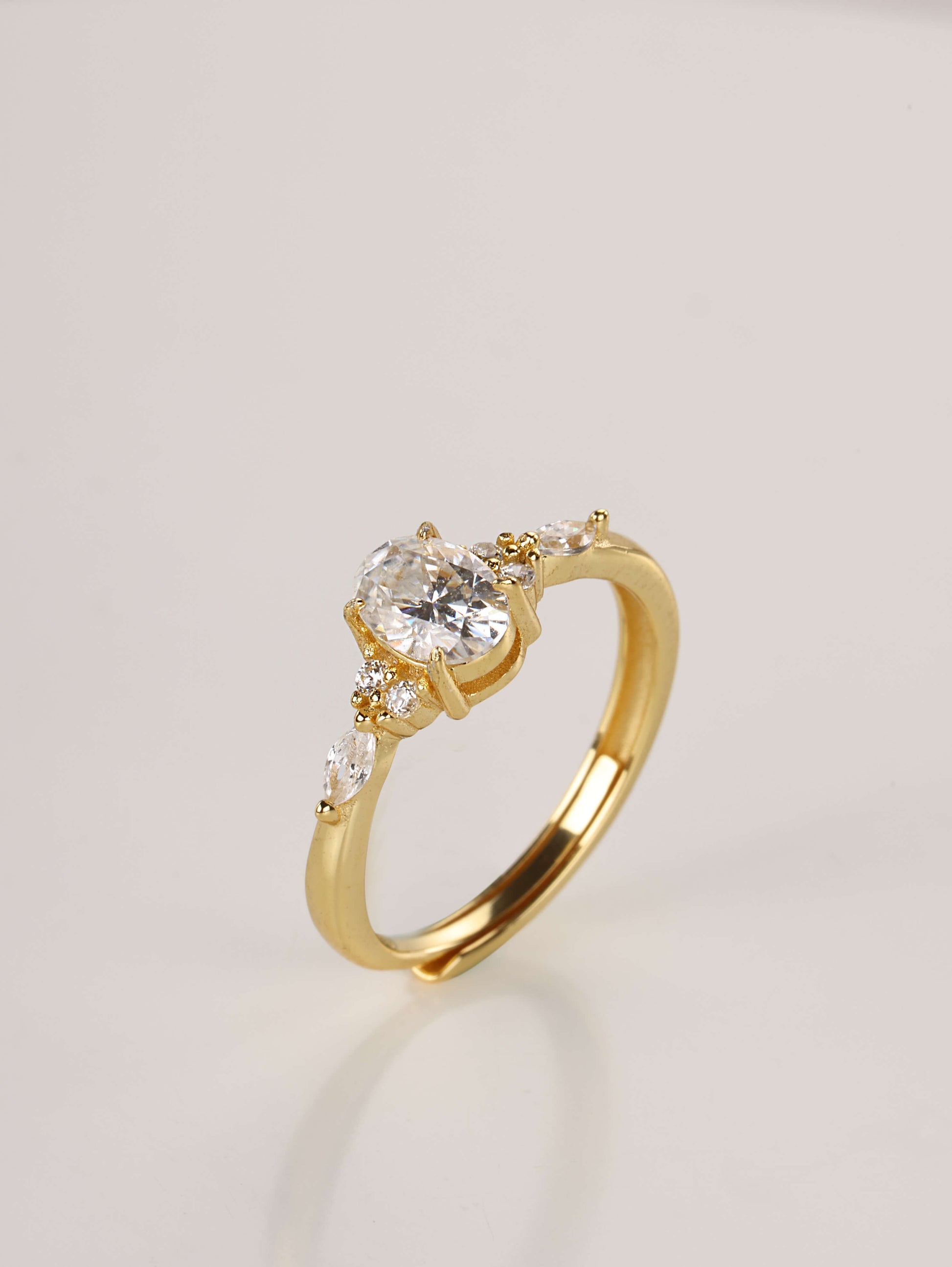 Close-up macro shot of the 1-carat oval moissanite ring showing the intricate cluster setting and polished gold band details.