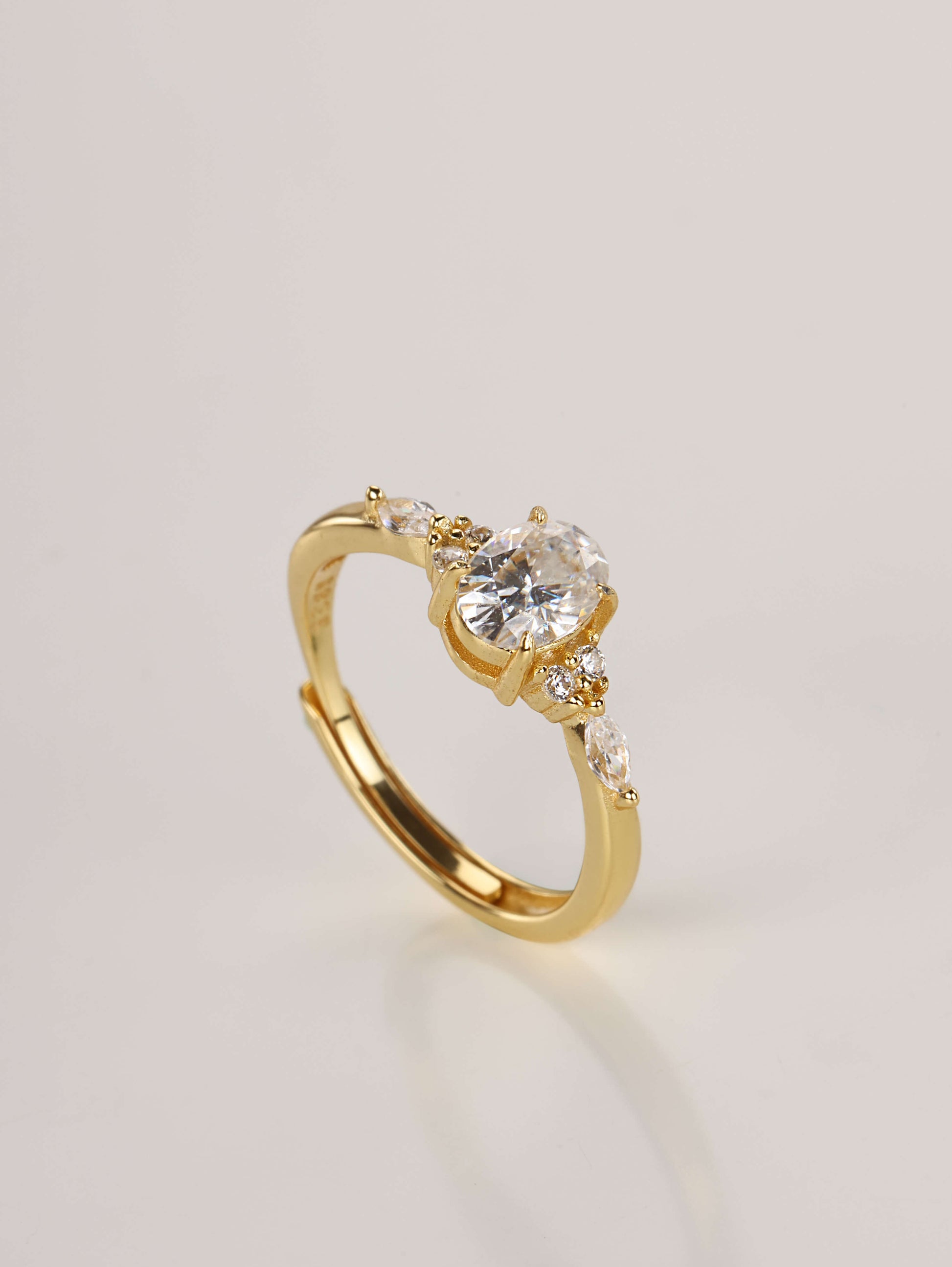 A close-up of a hand wearing the adjustable oval moissanite ring with side stones, demonstrating the fit and sparkle in natural lighting.
