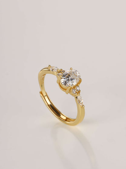 A close-up of a hand wearing the adjustable oval moissanite ring with side stones, demonstrating the fit and sparkle in natural lighting.