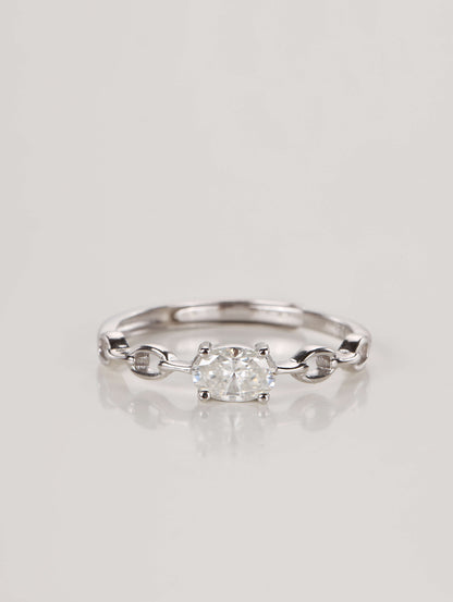 A silver adjustable ring featuring a 0.5-carat oval moissanite centre stone set horizontally on a chain-link style band, resting against a clean white background.
