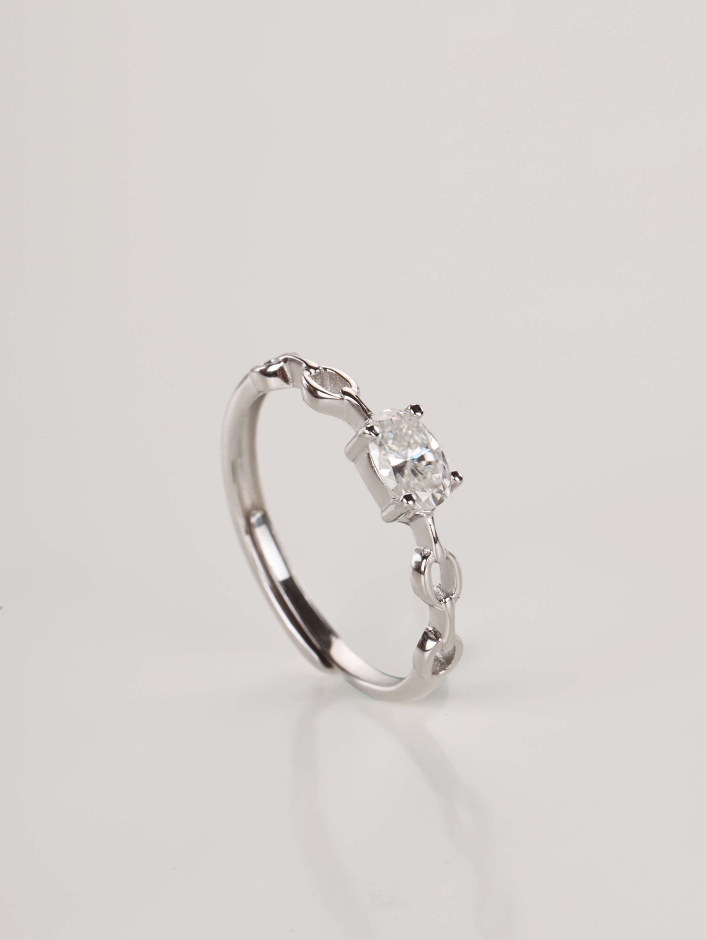 The 0.5-carat East-West oval chain link moissanite ring displayed beautifully next to its signature Earclipse luxury gift box and protective microfibre pouch.