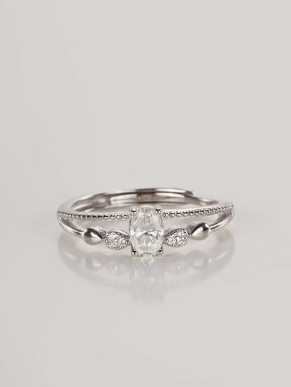 A silver adjustable ring featuring a 0.5-carat oval moissanite centre stone and a double-layer band with beaded detailing, resting against a clean white background