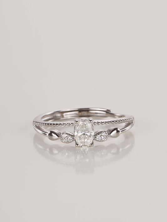 A silver adjustable ring featuring a 0.5-carat oval moissanite centre stone and a double-layer band with beaded detailing, resting against a clean white background
