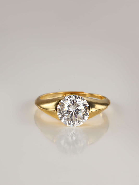 A chunky gold adjustable dome ring featuring a 2-carat round brilliant moissanite centre stone in a semi-flush setting, resting against a clean white background
