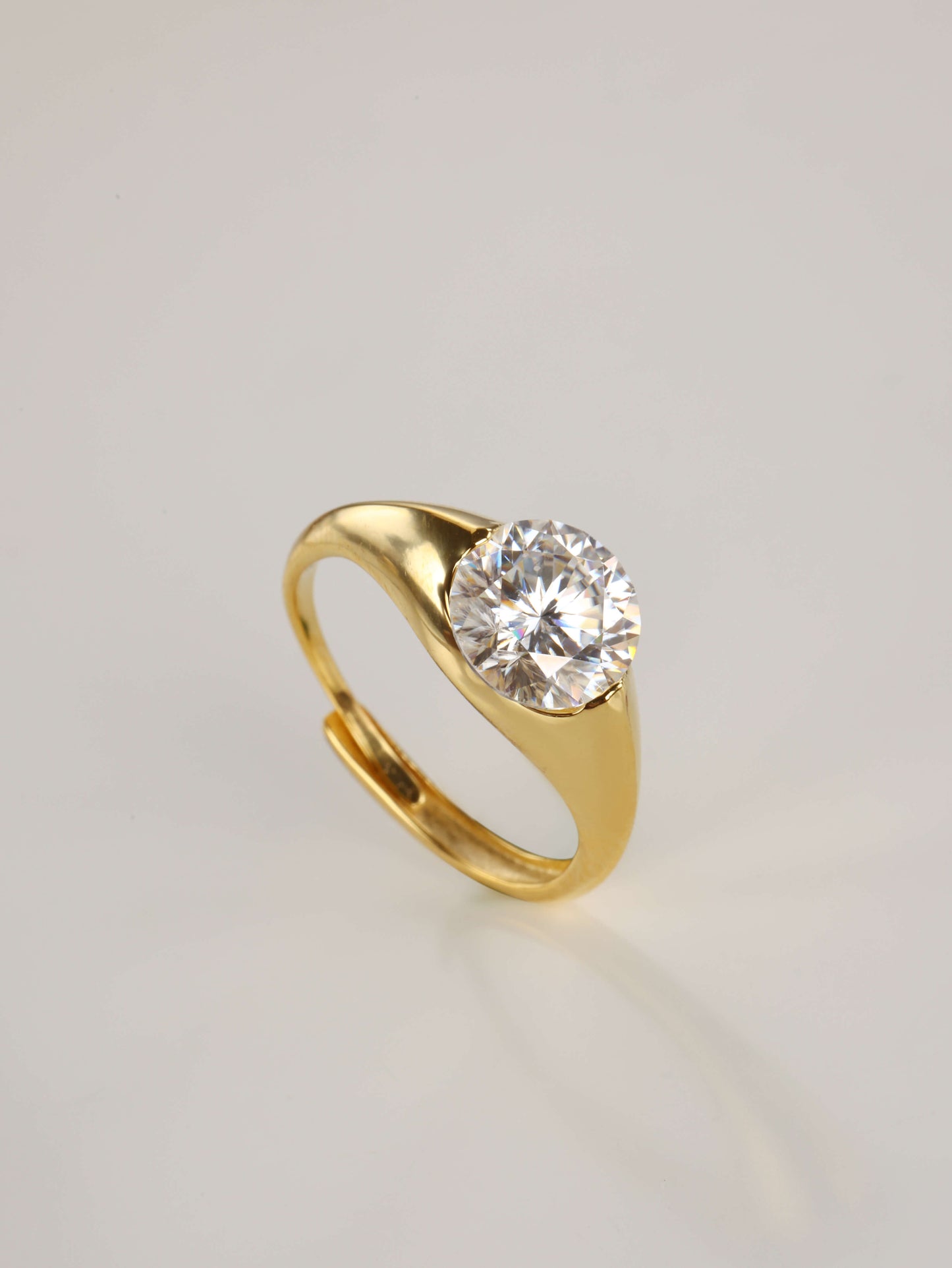 The modern 2-carat round moissanite minimalist ring resting gracefully beside its signature luxury gift box and protective microfibre pouch.