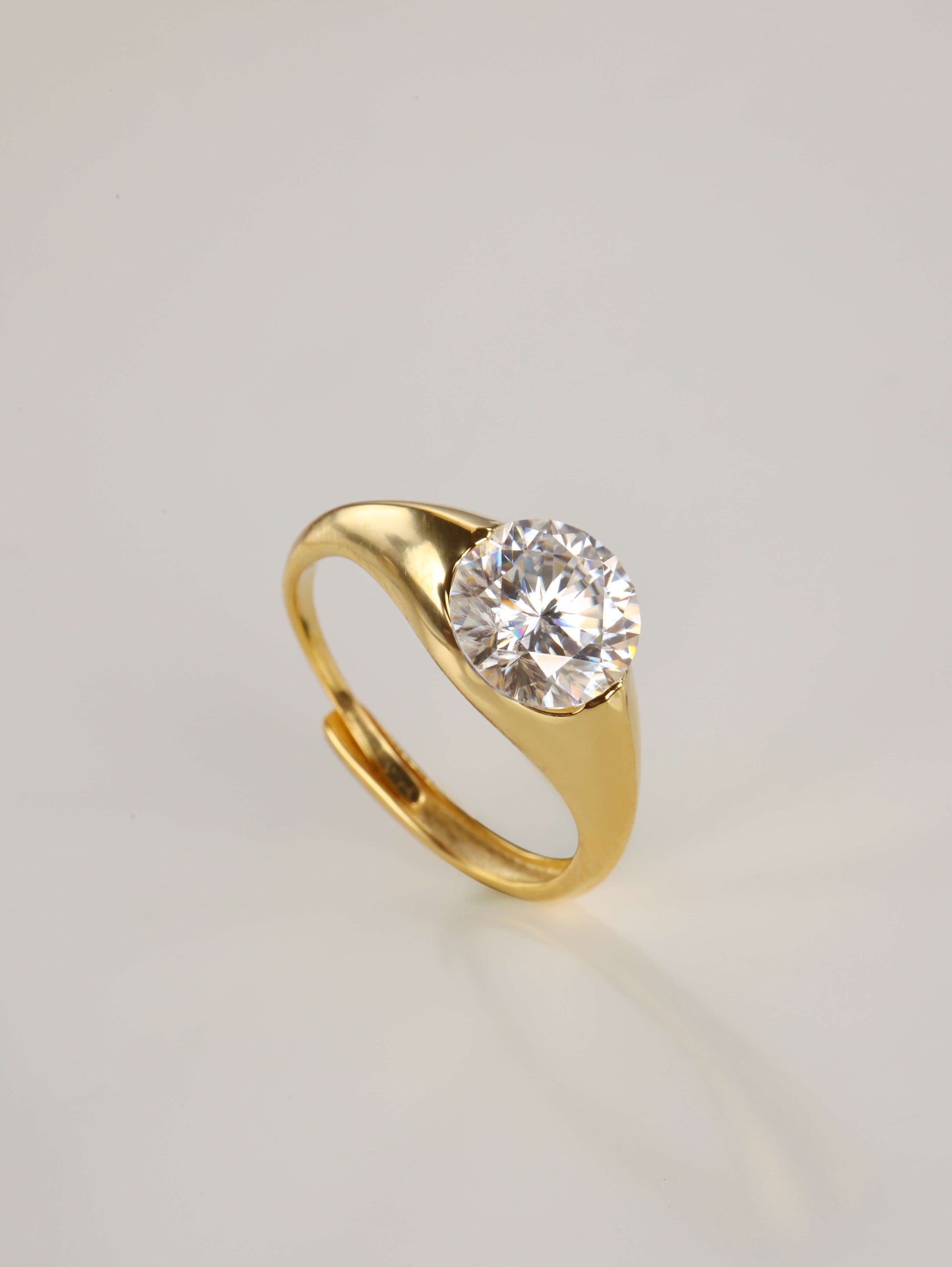 The modern 2-carat round moissanite minimalist ring resting gracefully beside its signature luxury gift box and protective microfibre pouch.