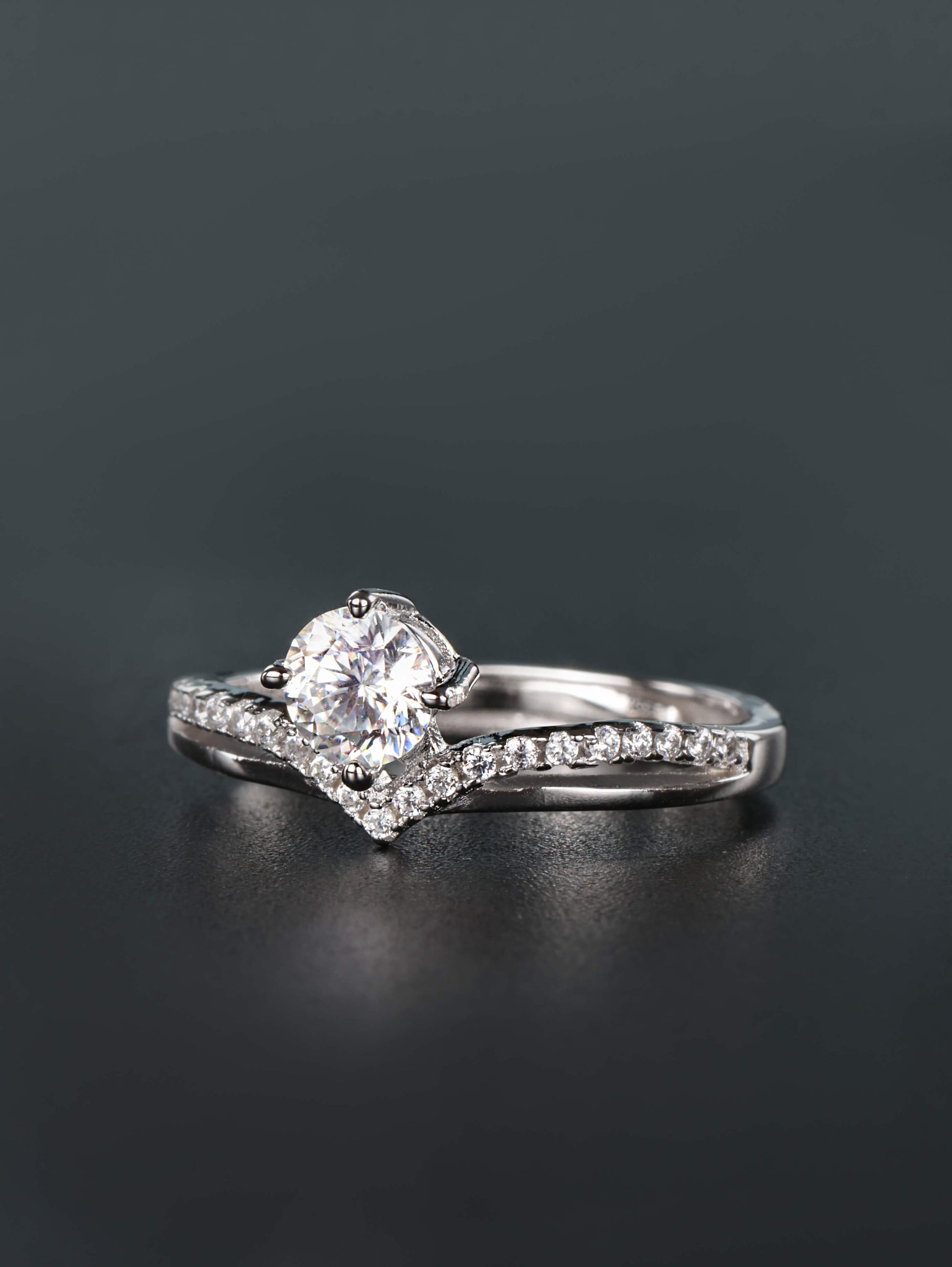 Adjustable open-back band detail on a silver crown chevron ring with a round prong-set moissanite gem