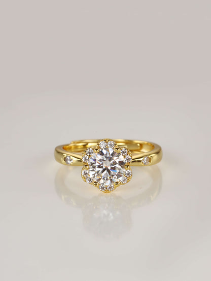 A gold adjustable ring featuring a 1-carat round moissanite centre stone surrounded by a floral halo design, resting on a clean white background, from the file image.png.