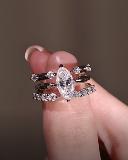 A close-up of a hand wearing the complete 3-ring marquise moissanite stacking set, demonstrating the seamless nested fit and sparkling everyday luxury in natural lighting.