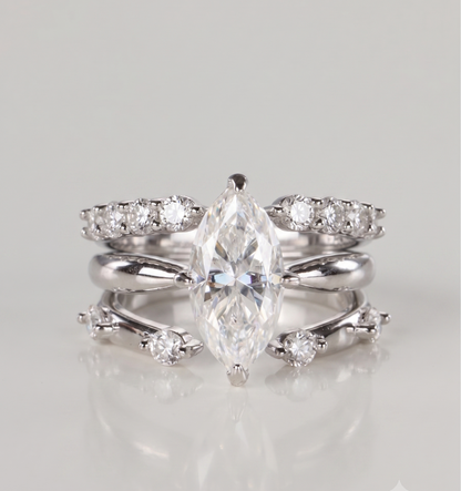 A 3-piece silver moissanite stacking ring set featuring a 2-carat marquise solitaire nested perfectly between an open-front stacker and a gap eternity ring, resting on a clean white background.
