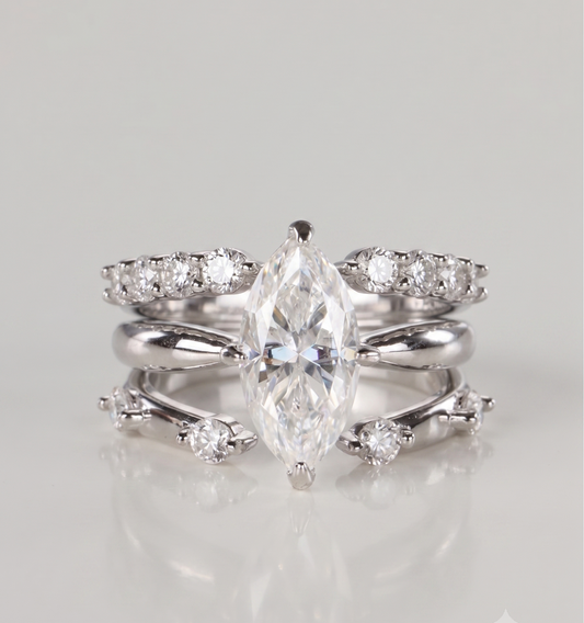 A 3-piece silver moissanite stacking ring set featuring a 2-carat marquise solitaire nested perfectly between an open-front stacker and a gap eternity ring, resting on a clean white background.