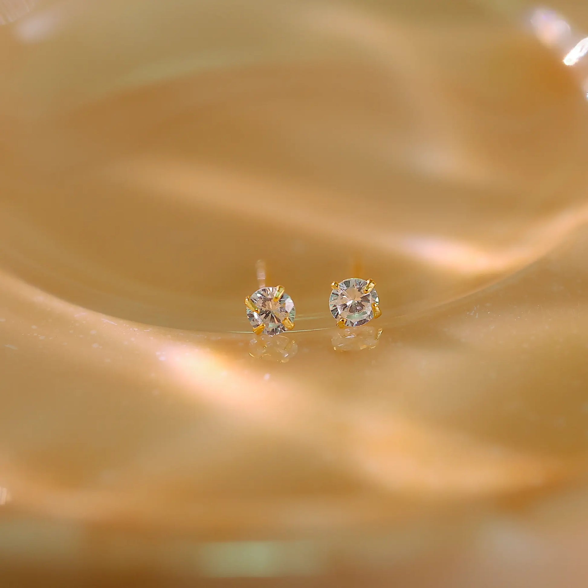 3mm diamond studs shown next to a ruler to demonstrate petite size.
