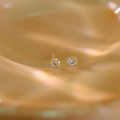 3mm diamond studs shown next to a ruler to demonstrate petite size.