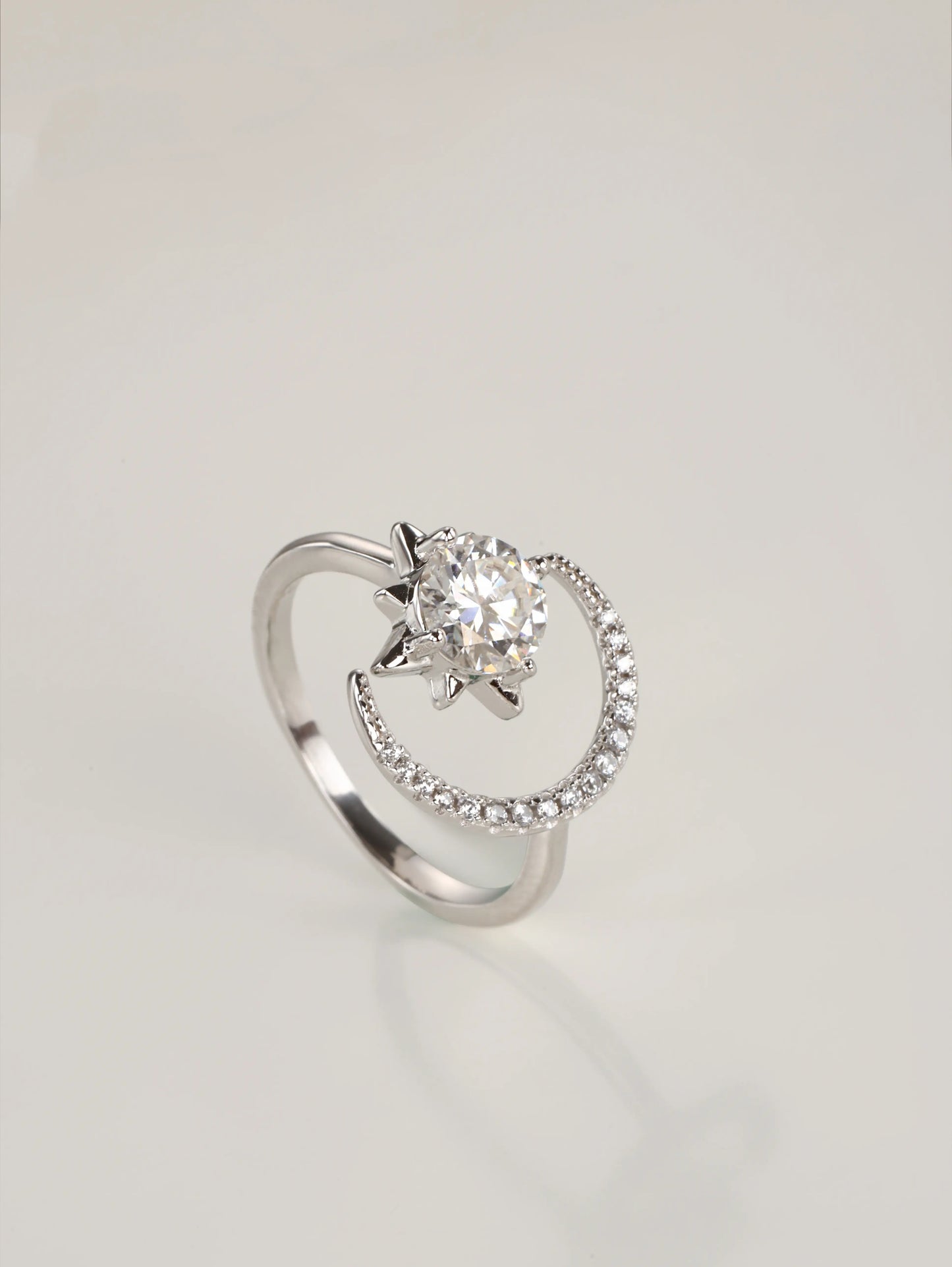 A close-up of a hand wearing the adjustable moon and star moissanite ring, showcasing the asymmetrical celestial design in natural lighting.