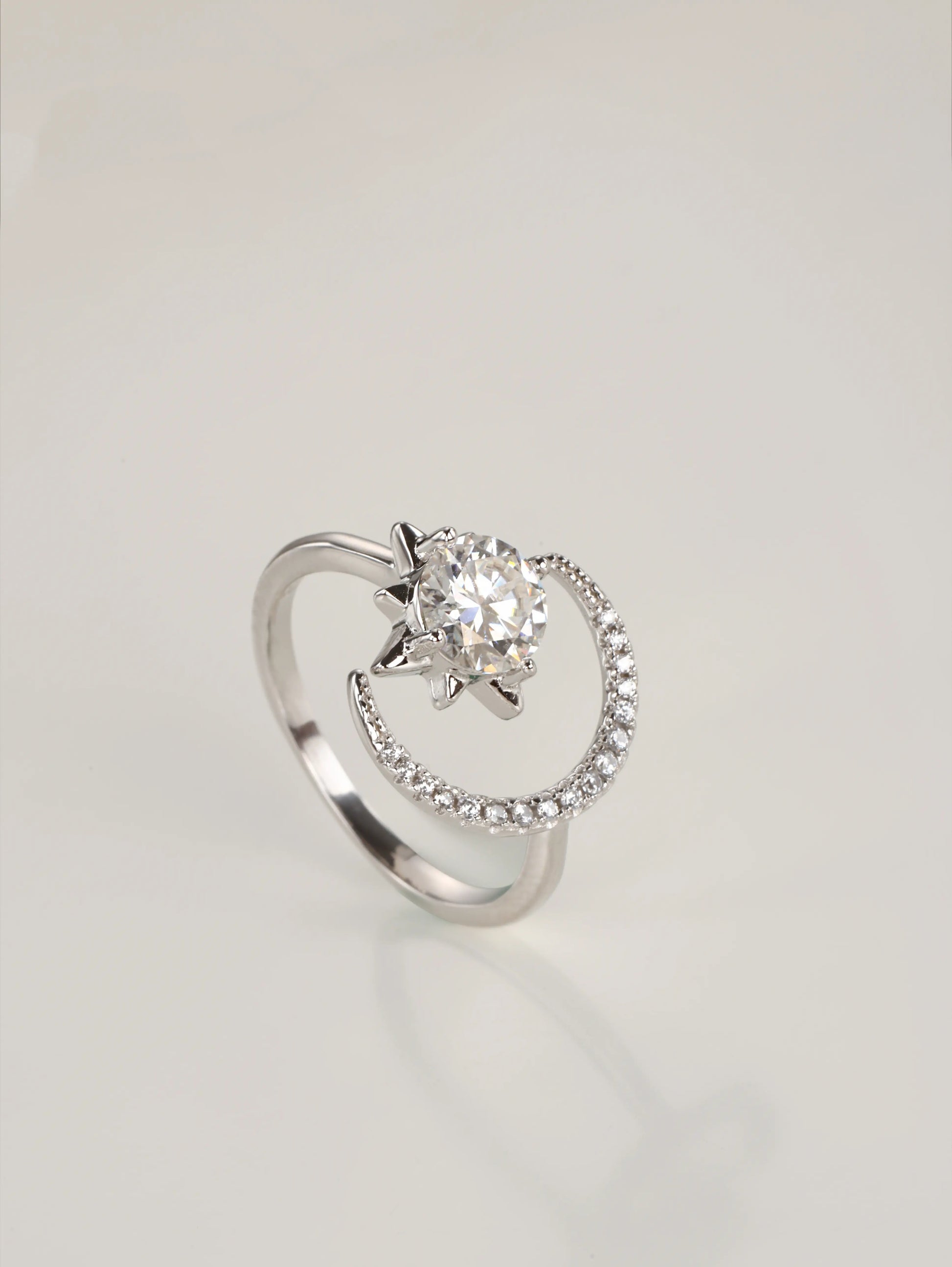 A close-up of a hand wearing the adjustable moon and star moissanite ring, showcasing the asymmetrical celestial design in natural lighting.