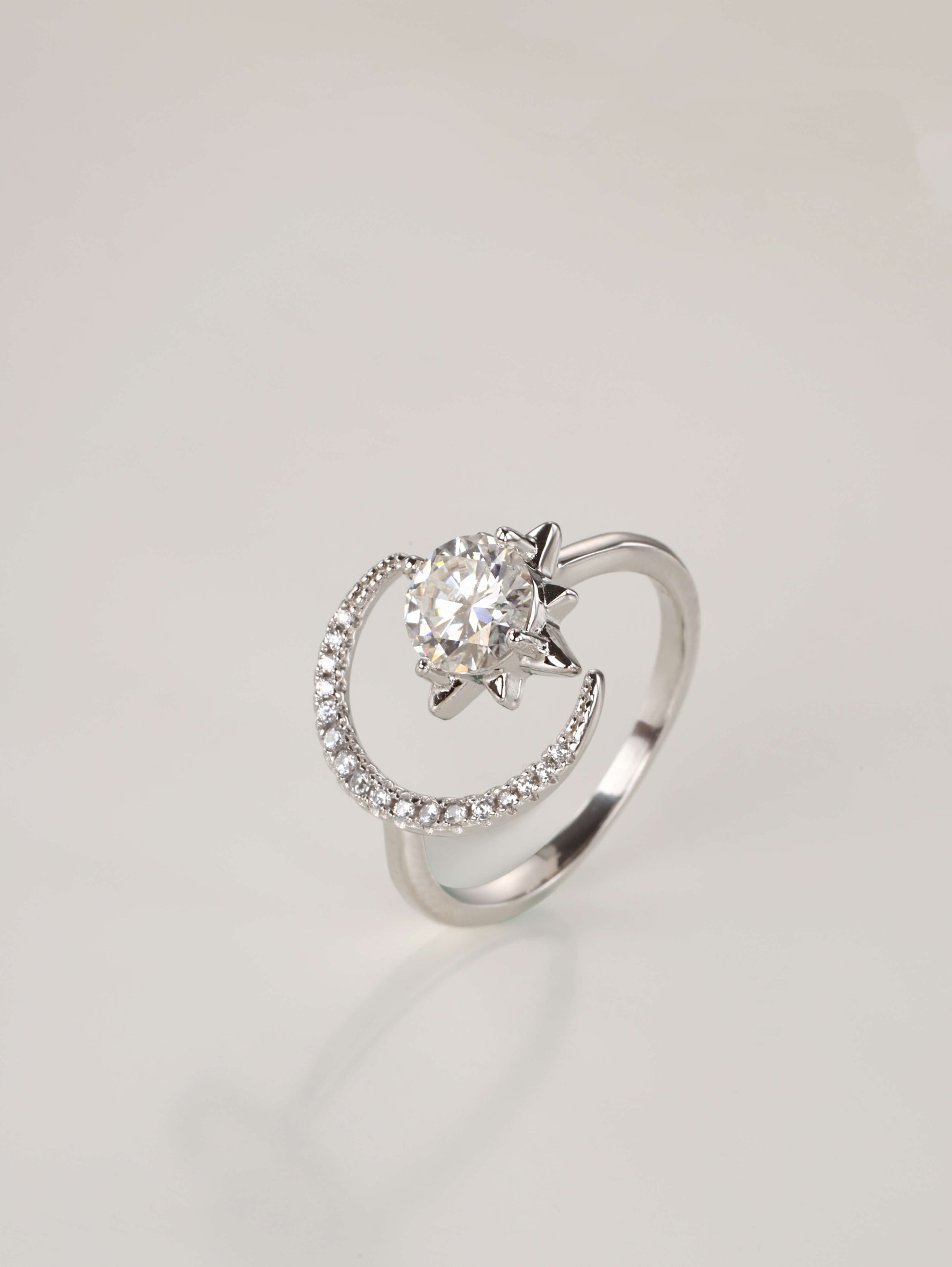 The whimsical moon and star moissanite ring displayed elegantly next to its signature luxury gift box and protective microfibre pouch.