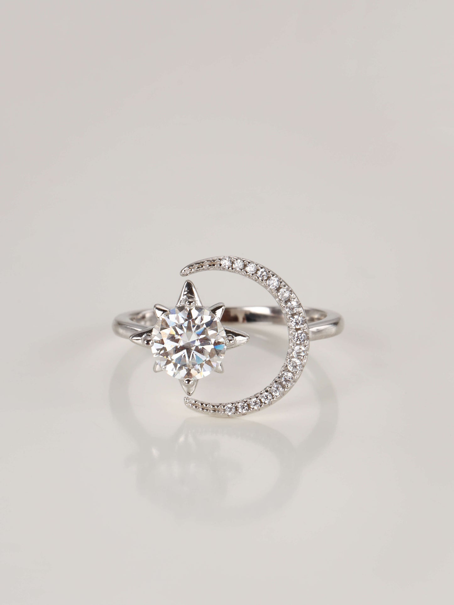 A 925 sterling silver adjustable ring featuring a 1-carat moissanite star and a pavé sparkling crescent moon, resting on a clean white background