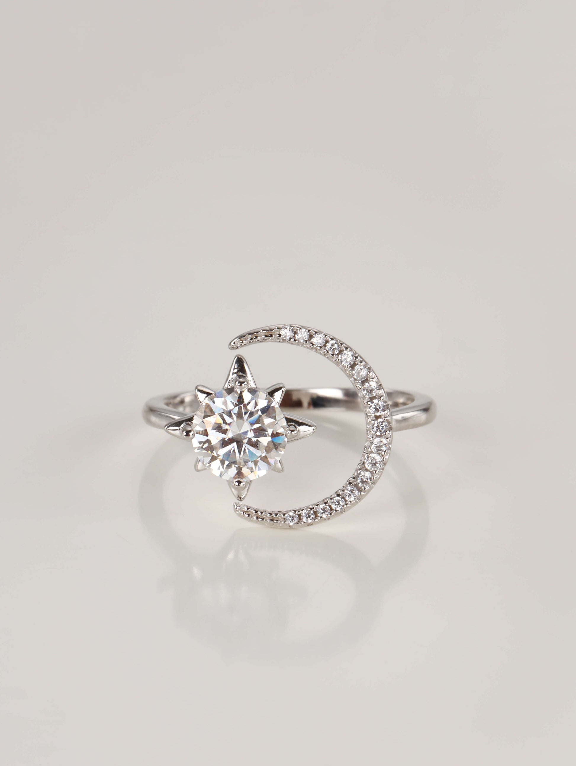 A 925 sterling silver adjustable ring featuring a 1-carat moissanite star and a pavé sparkling crescent moon, resting on a clean white background