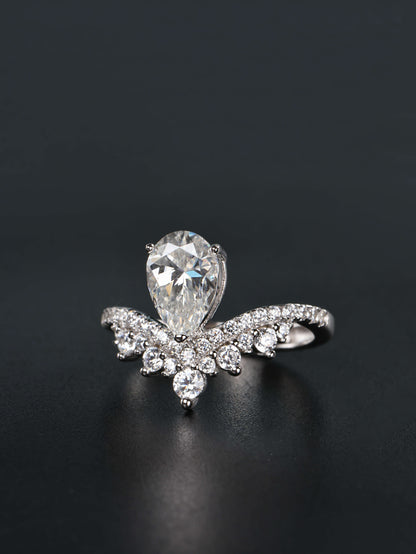 Alternative pear shaped moissanite engagement ring with a chevron tiara crown worn on a finger