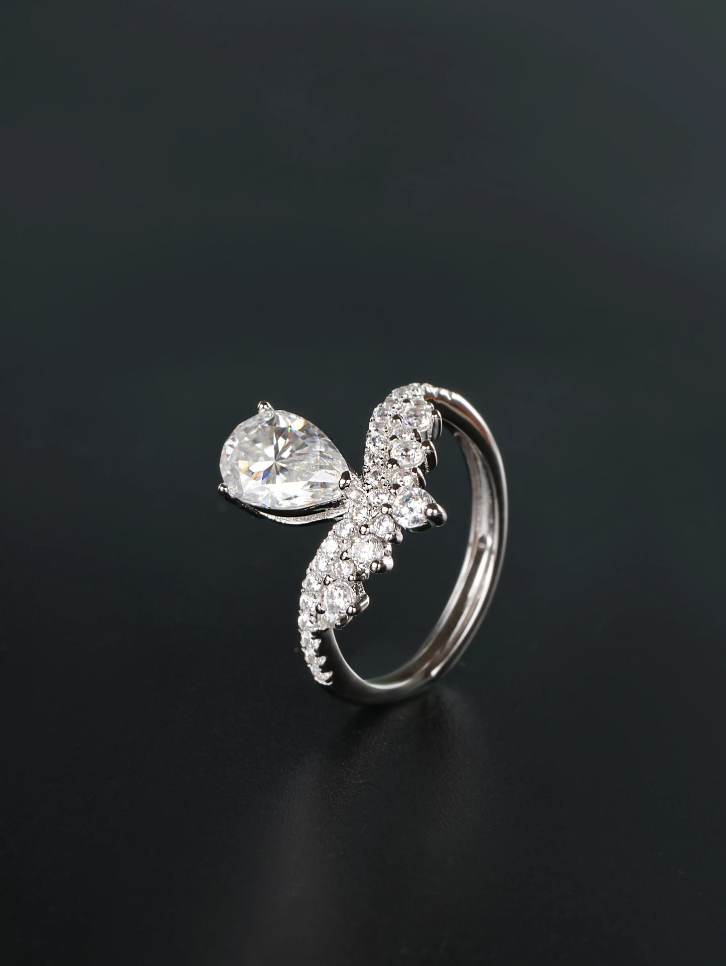 Hidden adjustable open back band detail on a silver 1.5ct pear cut chevron crown ring
