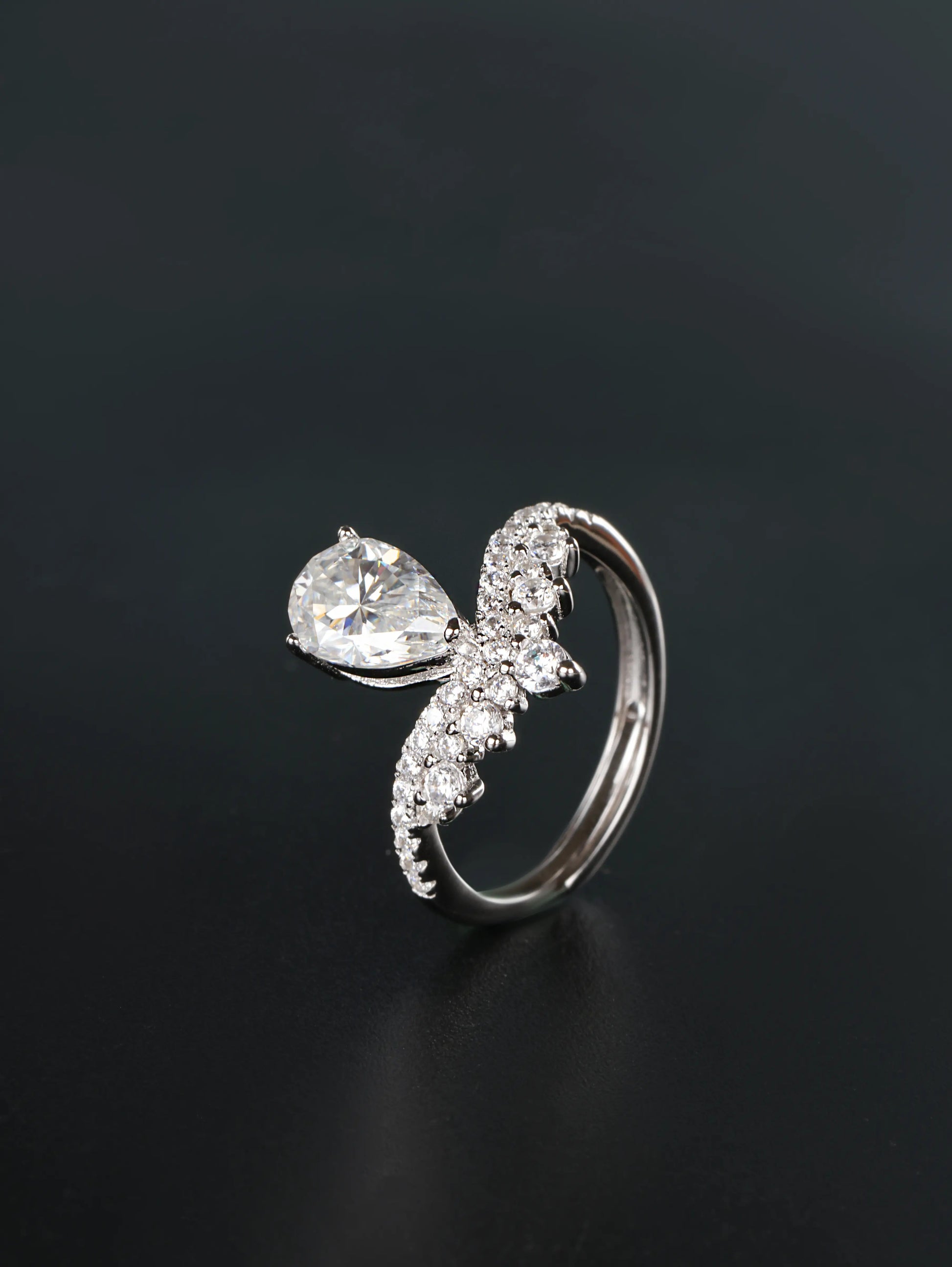 Hidden adjustable open back band detail on a silver 1.5ct pear cut chevron crown ring