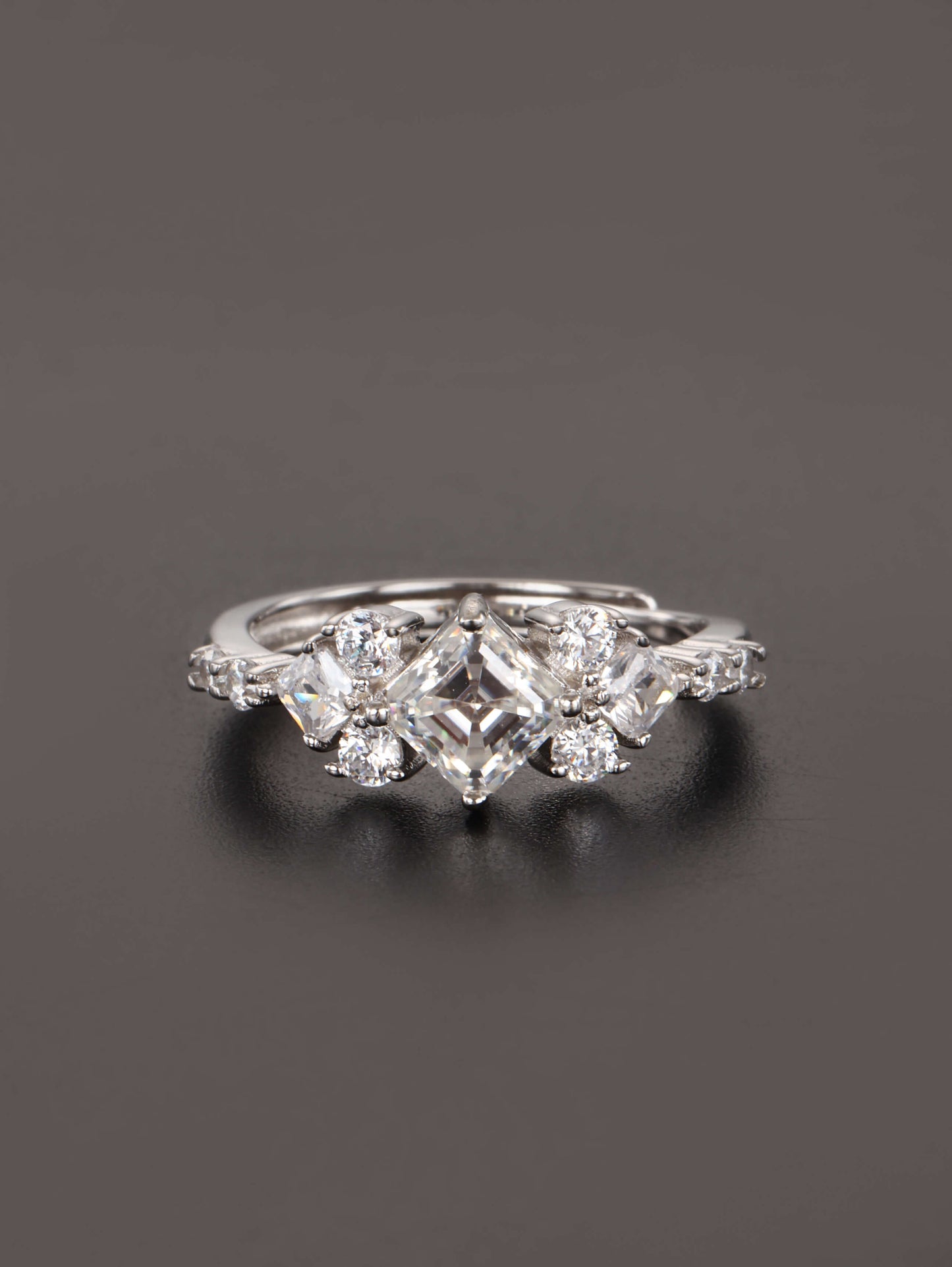 A close-up of a hand wearing the 1ct square cut moissanite ring, highlighting the geometric kite setting and brilliant side stones in natural lighting.