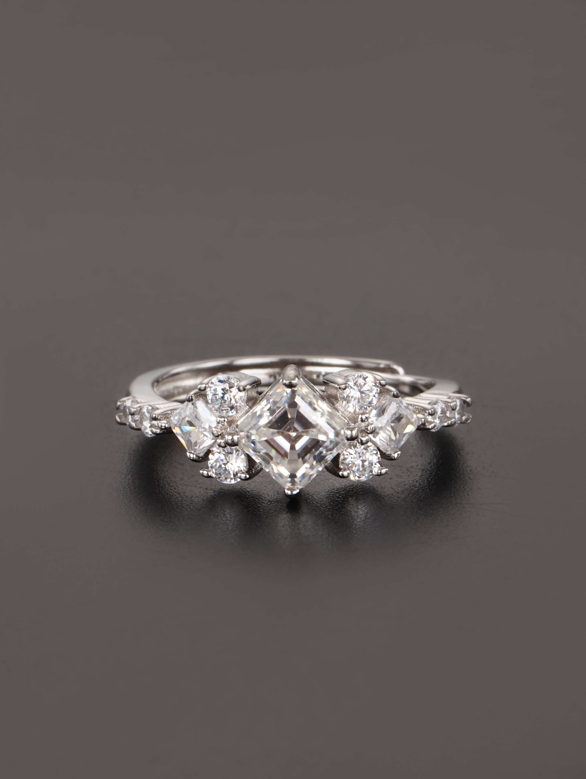 A close-up of a hand wearing the 1ct square cut moissanite ring, highlighting the geometric kite setting and brilliant side stones in natural lighting.