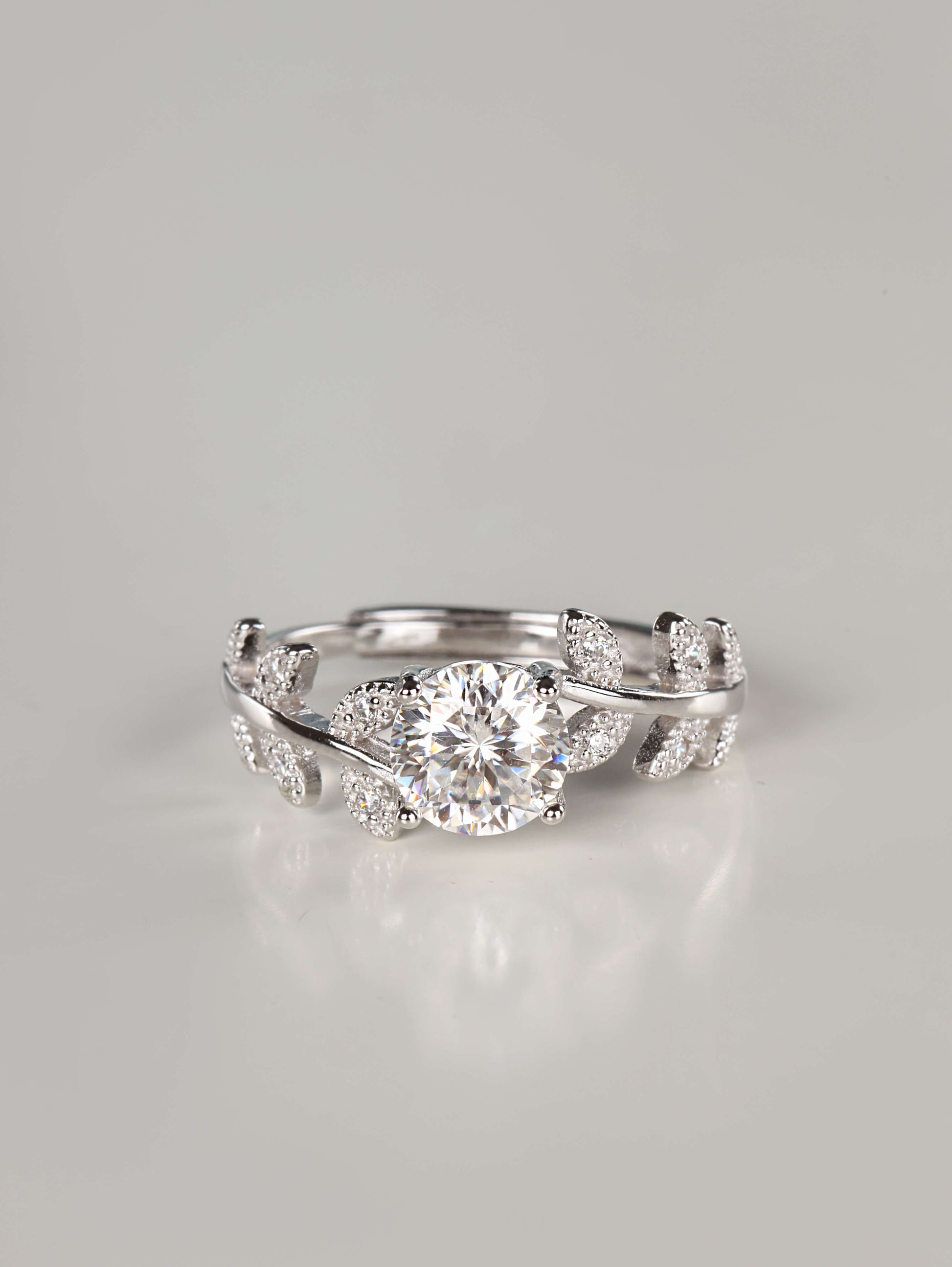 1ct brilliant round cut moissanite ring with silver leaf vine band on white background