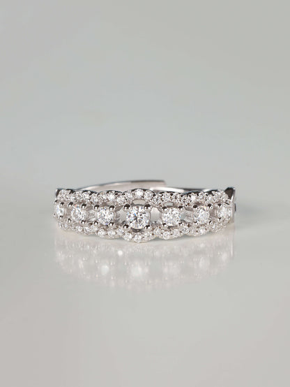 Close-up of a 0.41ct vintage-inspired silver lace eternity ring featuring a central row of brilliant moissanite stones bordered by scalloped pavé edges, resting on a clean reflective surface.
