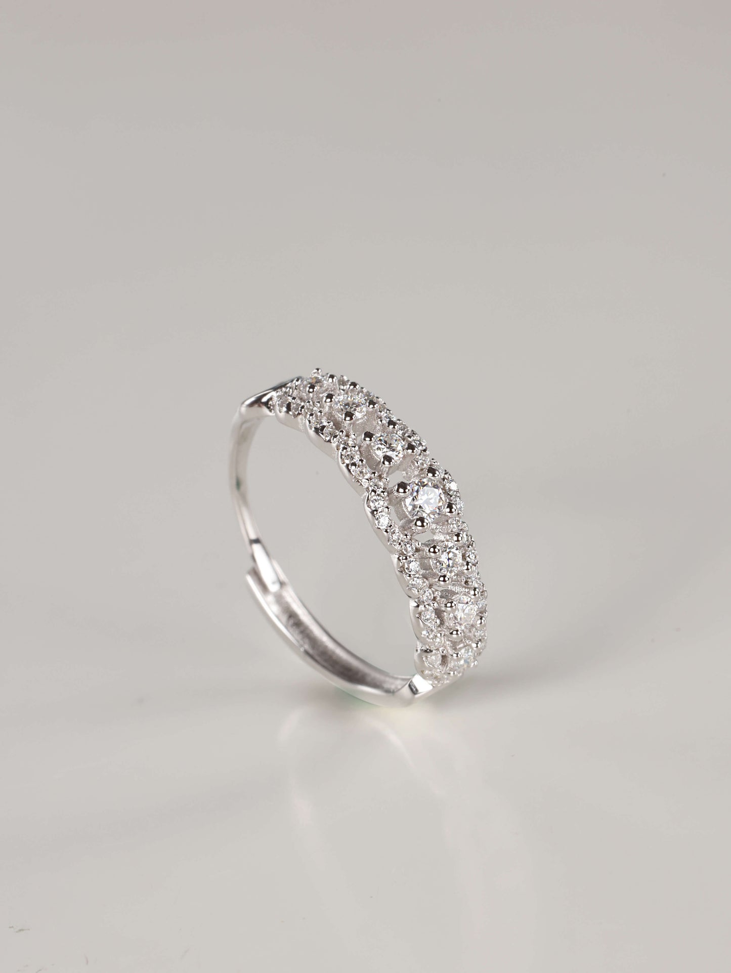 A woman's hand wearing a vintage-style 0.41ct moissanite lace eternity ring in 925 sterling silver. The ring features an intricate scalloped pavé design with a row of brilliant centre stones, showcasing its elegant, finger-flattering width.