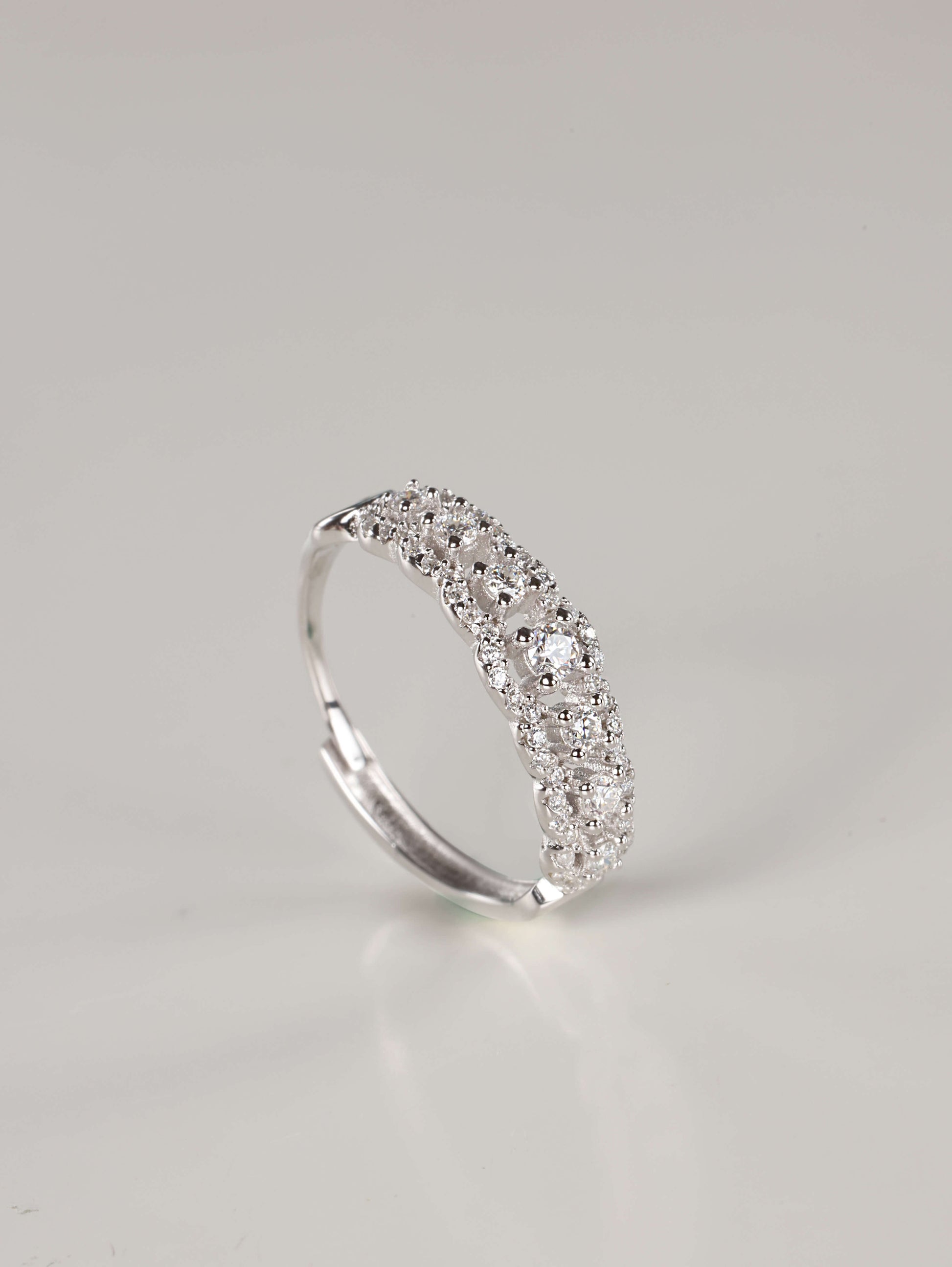 A woman's hand wearing a vintage-style 0.41ct moissanite lace eternity ring in 925 sterling silver. The ring features an intricate scalloped pavé design with a row of brilliant centre stones, showcasing its elegant, finger-flattering width.