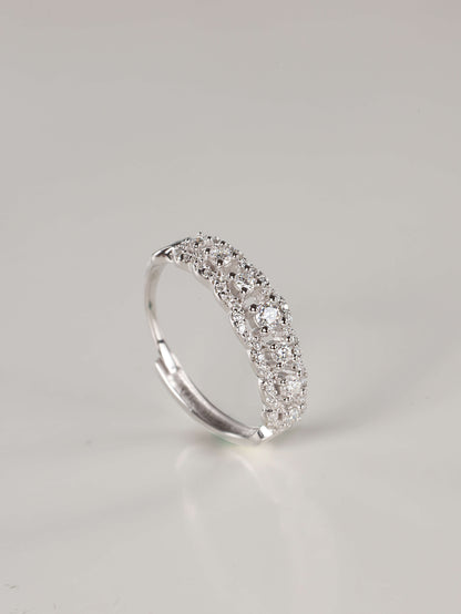 A woman's hand wearing a vintage-style 0.41ct moissanite lace eternity ring in 925 sterling silver. The ring features an intricate scalloped pavé design with a row of brilliant centre stones, showcasing its elegant, finger-flattering width.