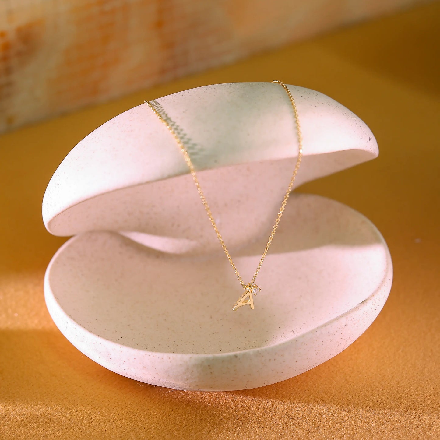 Side profile of gold letter pendant showing thick 14k gold vermeil finish. High-quality demi-fine personalized jewellery designed in London