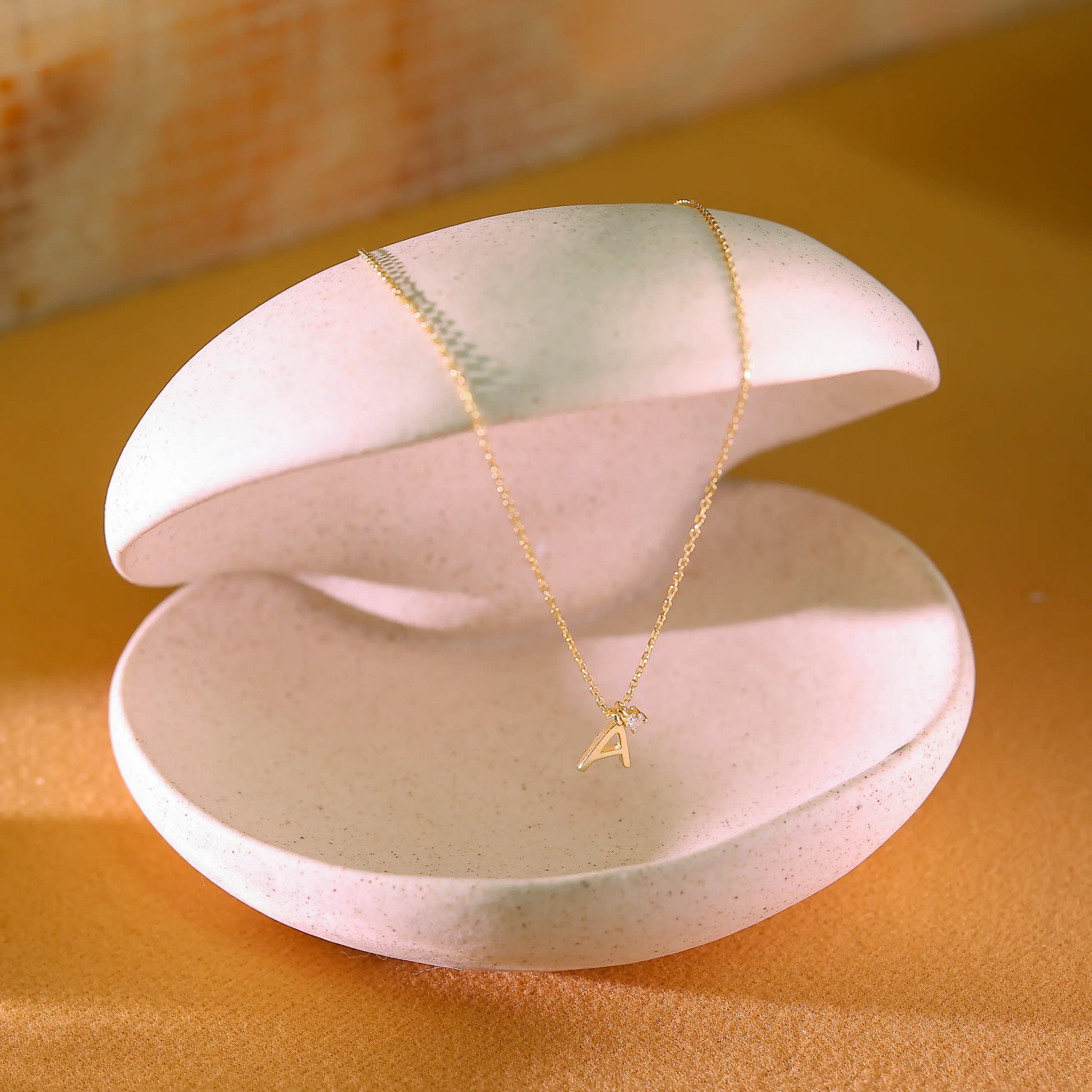 Side profile of gold letter pendant showing thick 14k gold vermeil finish. High-quality demi-fine personalized jewellery designed in London