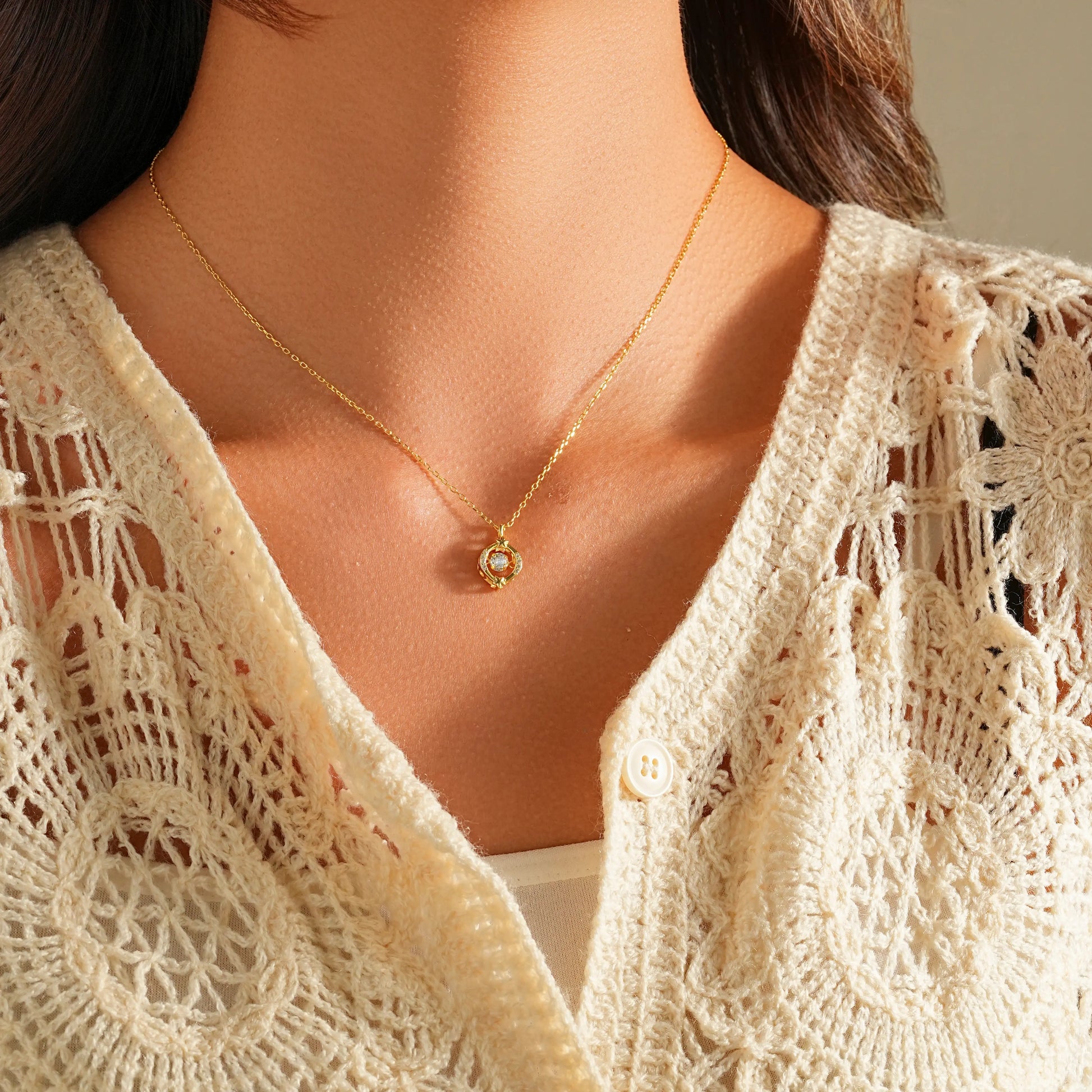Woman wearing a dainty floating diamond solitaire necklace with a white shirt.