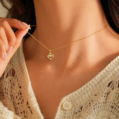 Close up of a single tiny diamond pendant resting on the collarbone, 14k gold chain.