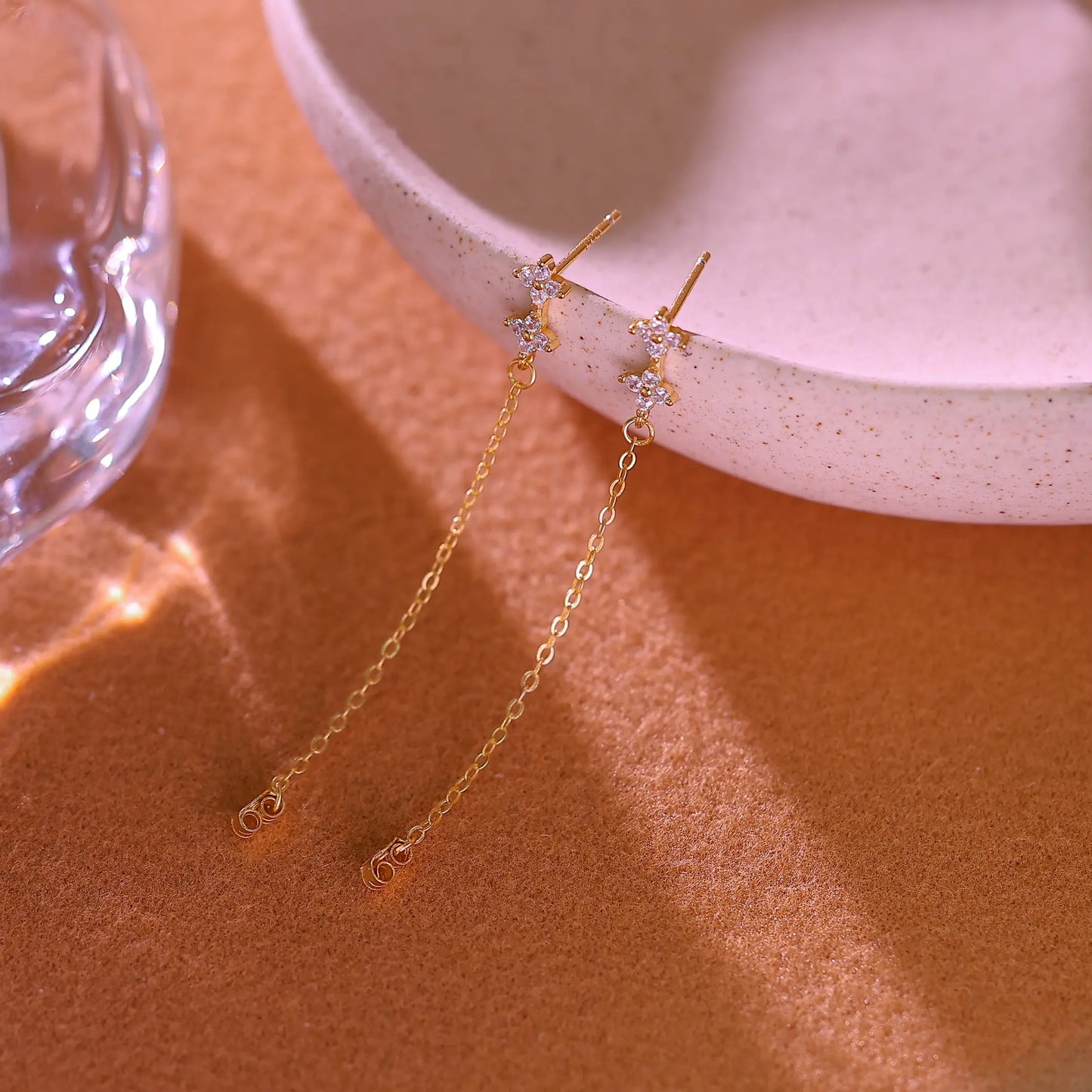 Pair of gold floral chain earrings laid flat on white background showing full 5cm length.