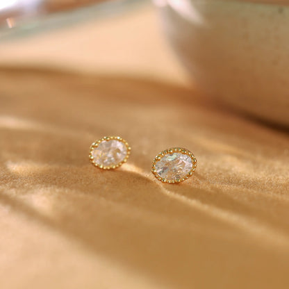 Pair of 14K gold plated sterling silver stud earrings with oval cubic zirconia stones.