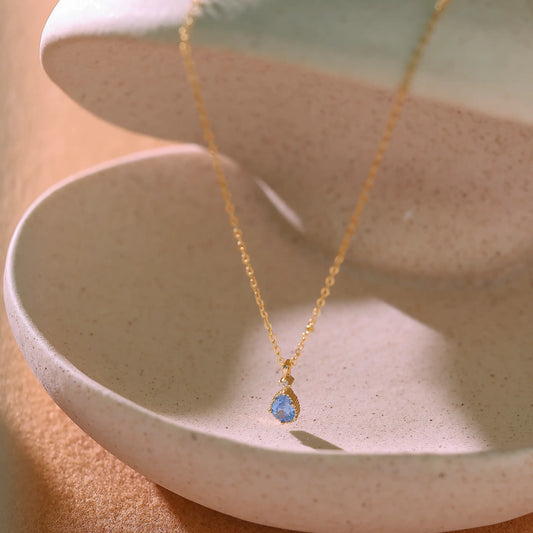 14K gold plated sterling silver necklace featuring a pear-shaped blue topaz pendant