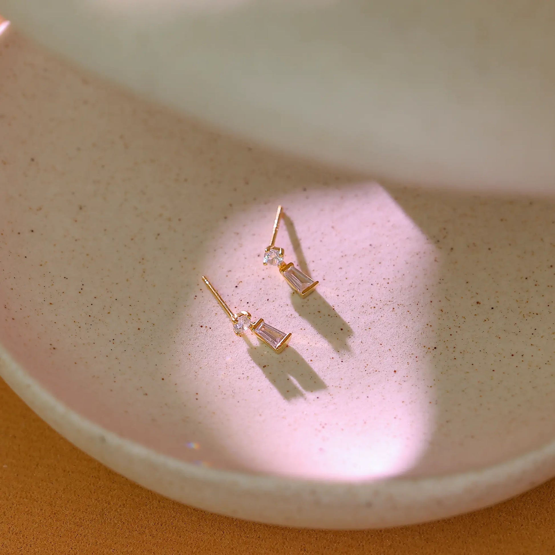 Tiny gold baguette drop earrings shown next to a ruler to demonstrate 13mm length.