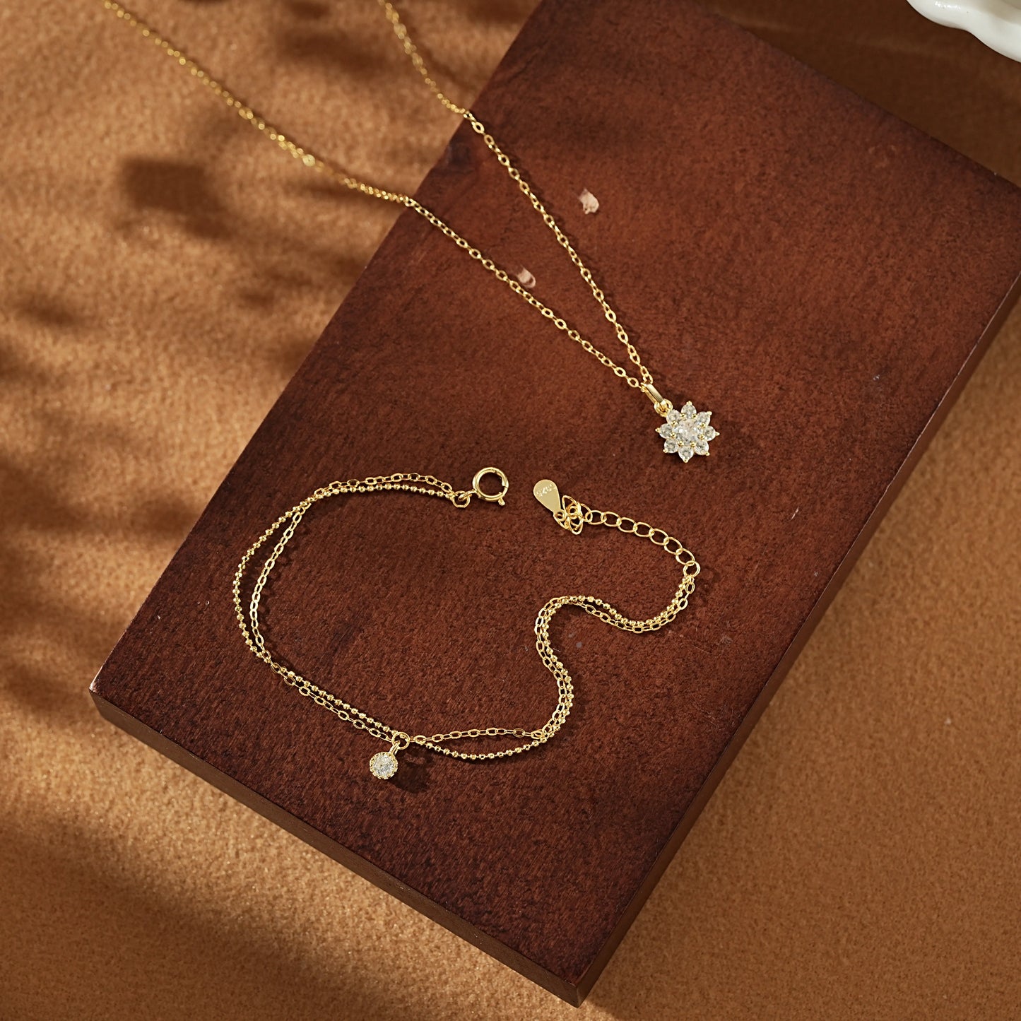 Open Dialuxé luxury gift box displaying a gold snowflake necklace and matching double-layer bracelet. The perfect ready-to-gift jewellery set for holidays or anniversaries.