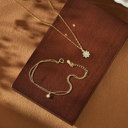 Open Dialuxé luxury gift box displaying a gold snowflake necklace and matching double-layer bracelet. The perfect ready-to-gift jewellery set for holidays or anniversaries.