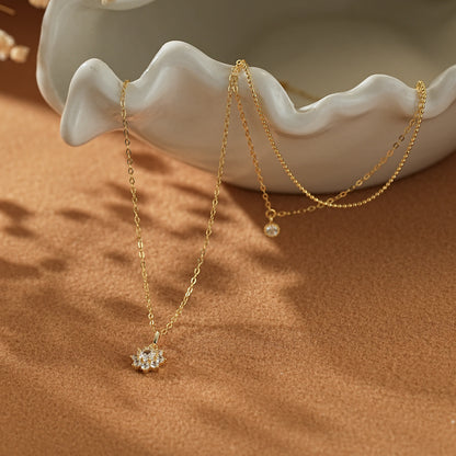 Macro close-up showing the micro-pave stones on the gold snowflake pendant and the delicate chain texture of the double-layer bracelet. High-quality demi-fine craftsmanship.